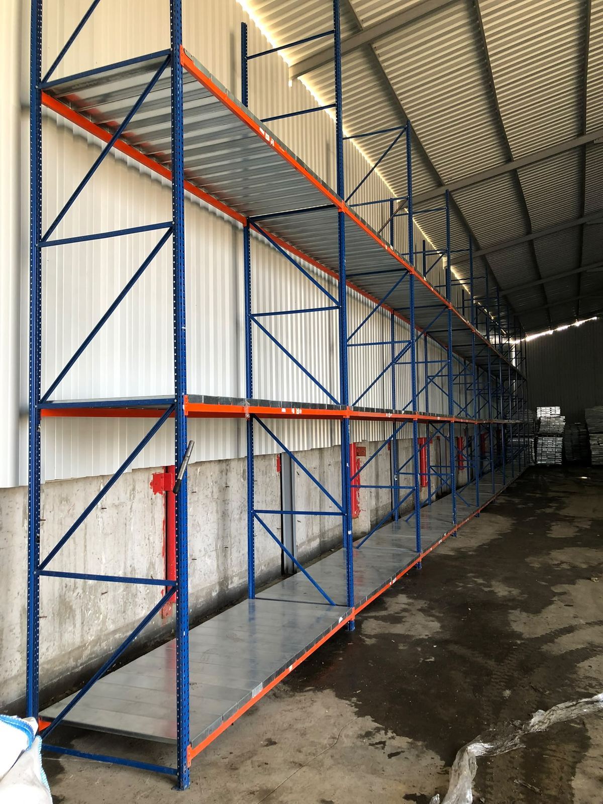 Stoğu çekilmiş, gözleri boşalmış uzun palet rafı hattı ve önündeki temiz koridor