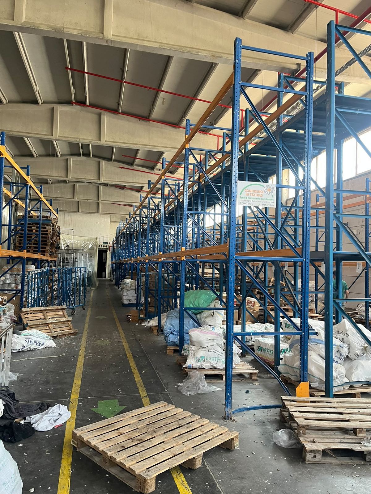 Depo rafı hattının önünde boş ahşap paletlerin durduğu yükleme alanı