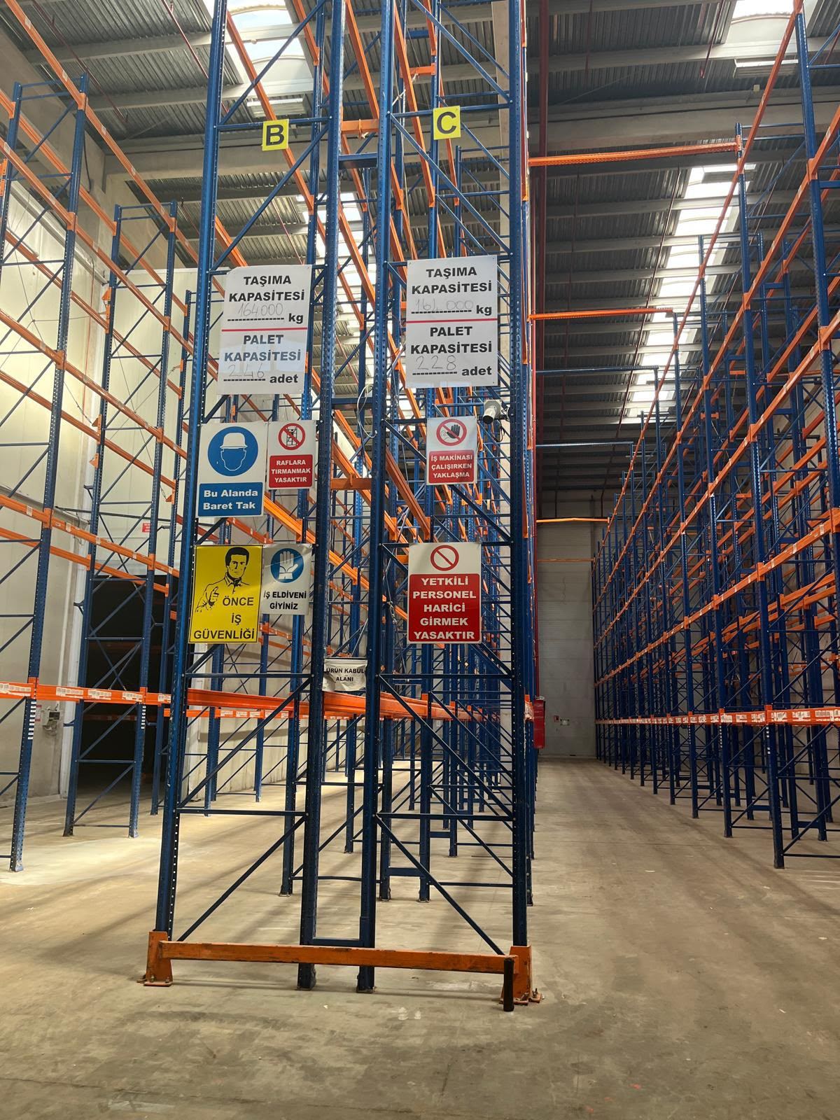 İkinci El Lojistik Ağır Yük Depo ve Palet Rafları, koridor harfleri ve kapasite levhaları asılı yüksek hatlar