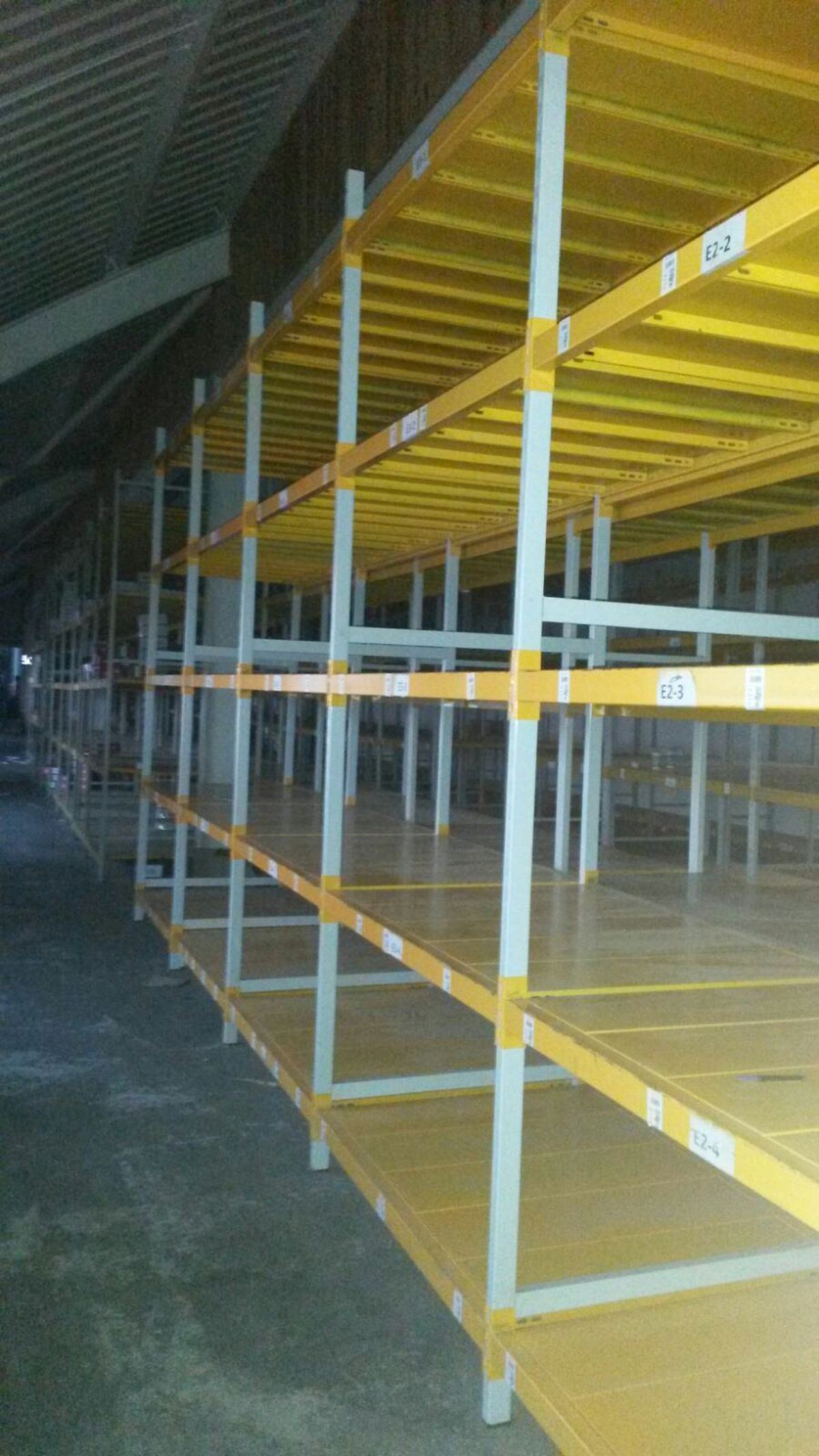 Gözleri boş, farklı kat aralıklarıyla kurulmuş sarı traversli hafif yük rafı hattı